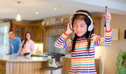 Young girl listening to music and dancing