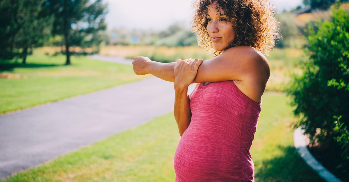 pregnant woman stretching arm