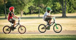 two kids riding bikes in the park
