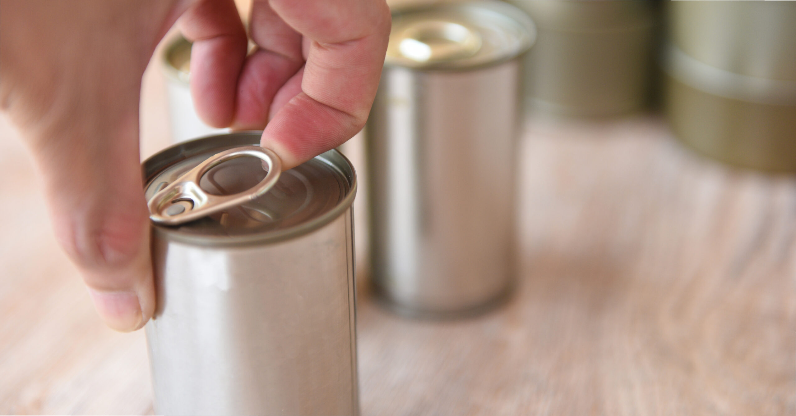 Person opening canned vegetables