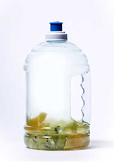 Orange and kiwi in large plastic water jug