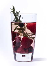 Various berries and rosemary infused water in a glass